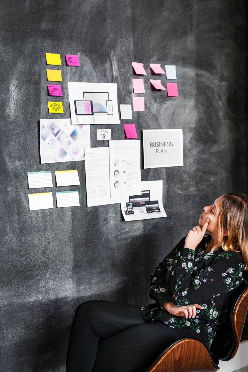Leader in a startup company brainstorming using a blackboard