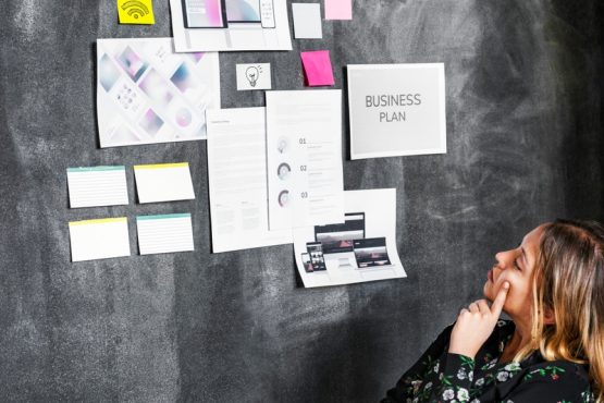 Leader in a startup company brainstorming using a blackboard